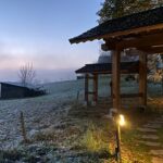 Torhaus des Johanneshofs im Herbstlicht, Morgennebel über der Wiese